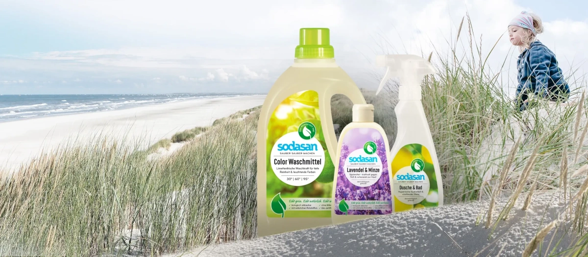 KI generiert: Das Bild zeigt links eine Tasse Kaffee mit Milch auf einem Tisch und in der Mitte eine Kaffeeverpackung. Rechts ist eine Person zu sehen, die an einer Kaffeemaschine arbeitet.