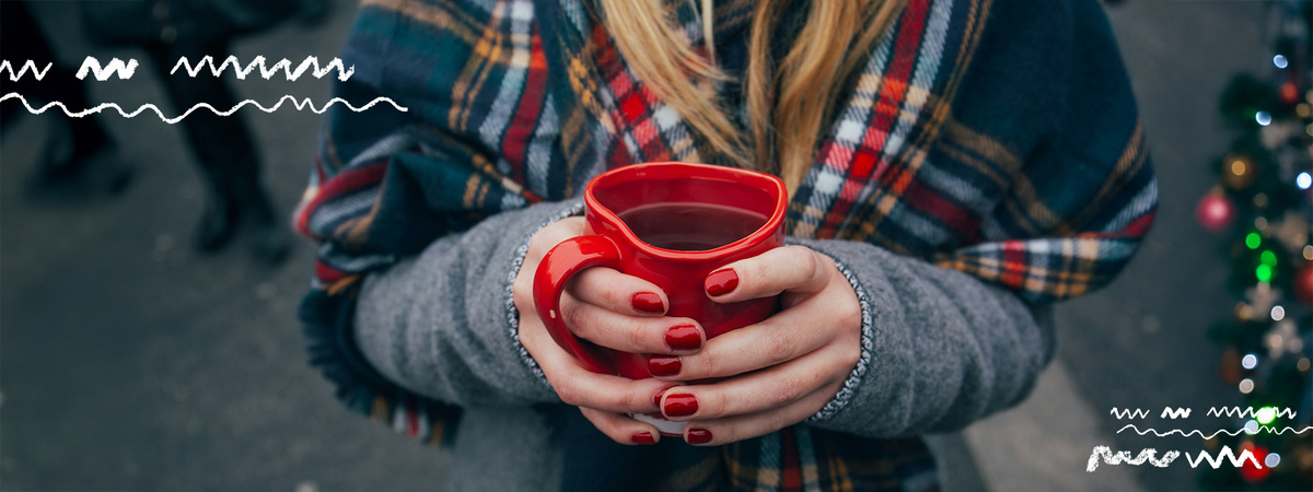 KI generiert: Person hält eine rote Tasse; weihnachtliche Atmosphäre; keine weiteren Details.