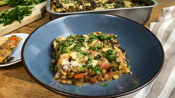 KI generiert: Ein Teller mit einer Linsen-Gemüse-Lasagne, garniert mit frischen Kräutern.
