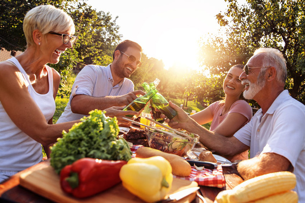 KI generiert: Eine Gruppe von vier Personen genießt ein Picknick im Freien bei Sonnenuntergang.