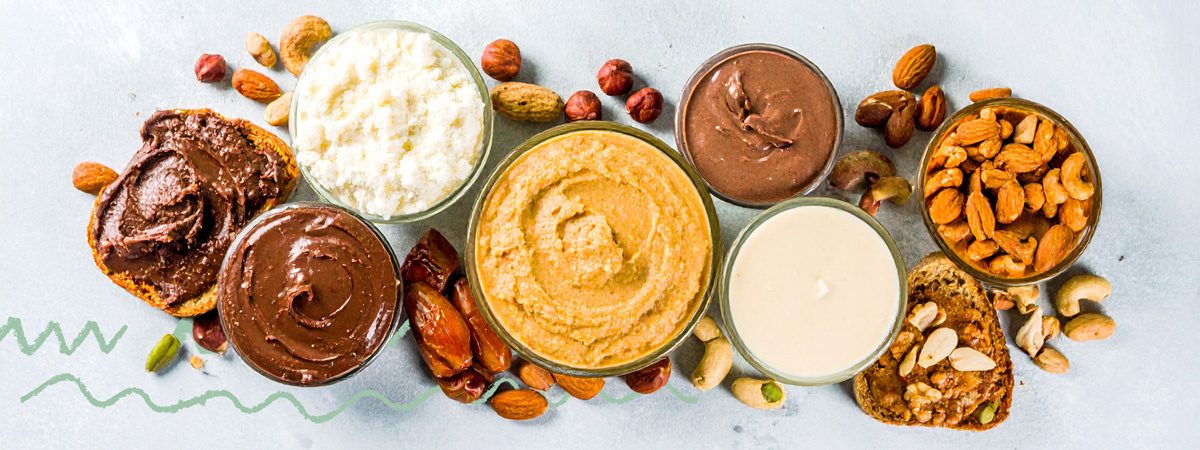 KI generiert: Verschiedene Nusscremes und Nüsse auf einem Tisch arrangiert.