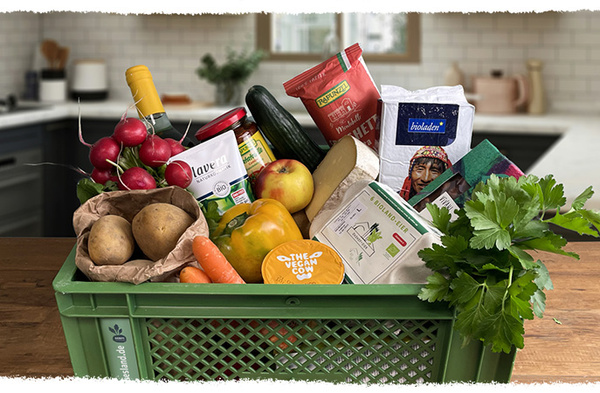 KI generiert: Eine grüne Kiste voller Gemüse, Obst und veganer Produkte in einer Küche.