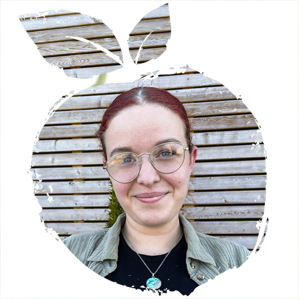 KI generiert: Ein Porträt einer Person mit Brille und rotem Haar, Holz-Hintergrund, umrahmt von einem Apfelmotiv.