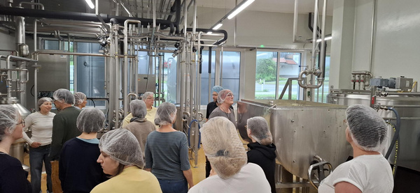 KI generiert: Gruppe von Menschen in einer Brauerei bei einer Führung.