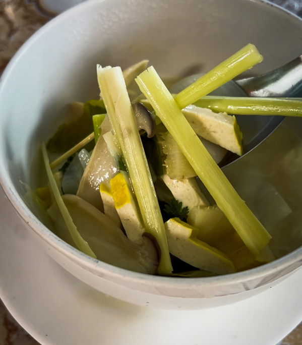KI generiert: Ein Teller mit Gemüsesuppe und einem Löffel.